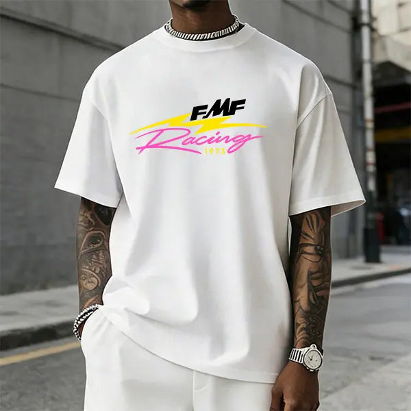 Men’s FMF Racing 1973 graphic T-shirt featuring a retro pink/yellow lightning logo print, made from a soft cotton blend—perfect for motocross fans, streetwear enthusiasts, and casual motorsport-inspired outfits.