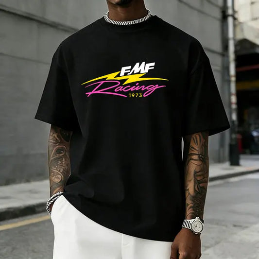 Men’s FMF Racing 1973 graphic T-shirt featuring a retro pink/yellow lightning logo print, made from a soft cotton blend—perfect for motocross fans, streetwear enthusiasts, and casual motorsport-inspired outfits.